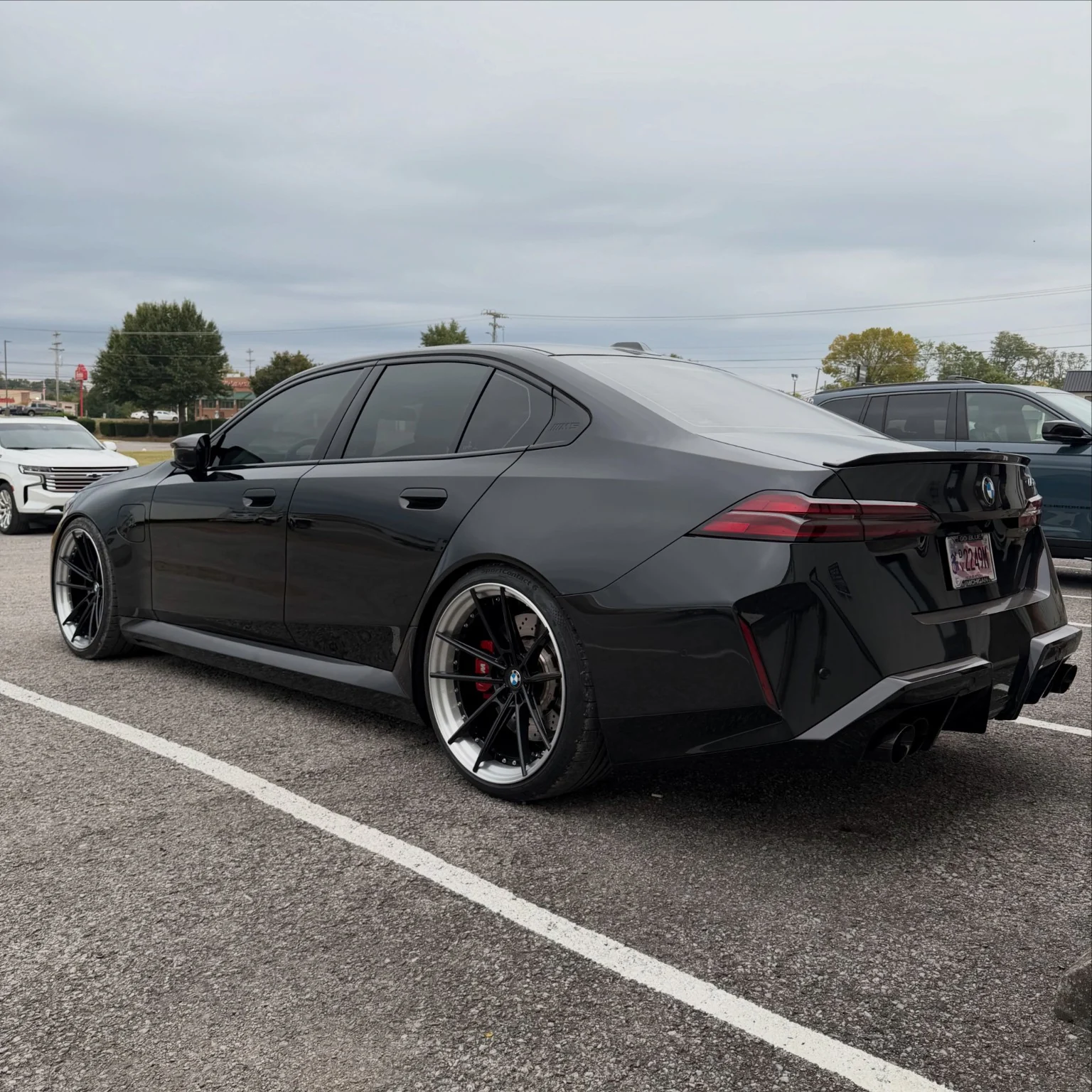 Black BMW with aftermarket-style wheels photographed outdoors